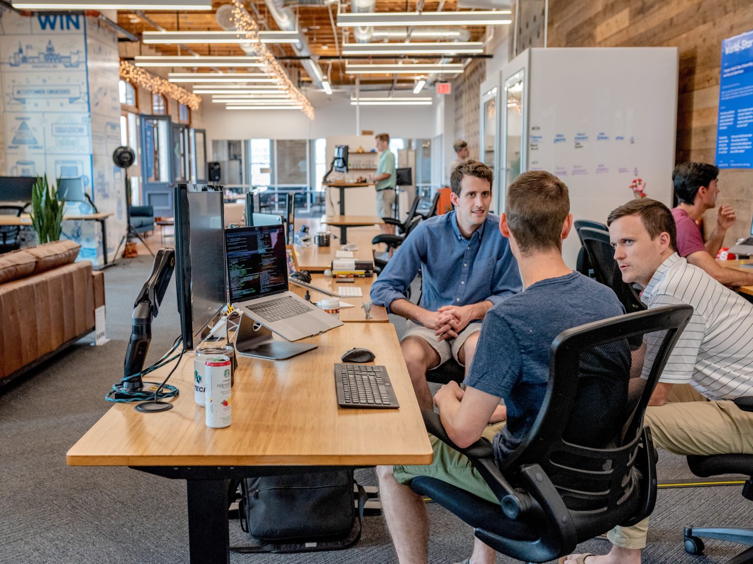 meeting at the desk between 3 people - busy office